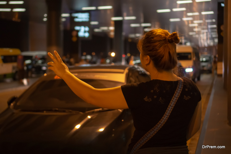 Woman hailing for cab at night in an airport