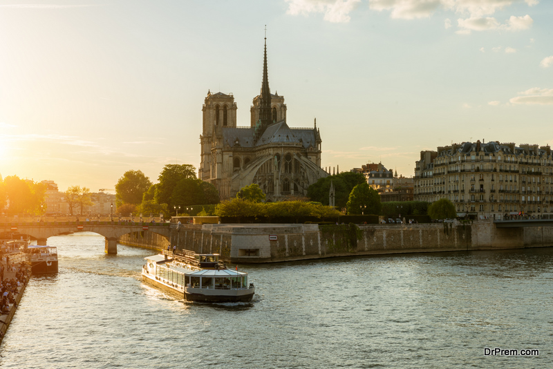 Notre Dame de Paris with cruise ship on Seine river in Paris, France