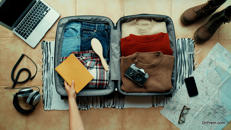 Woman packs winter themed suitcase for holiday